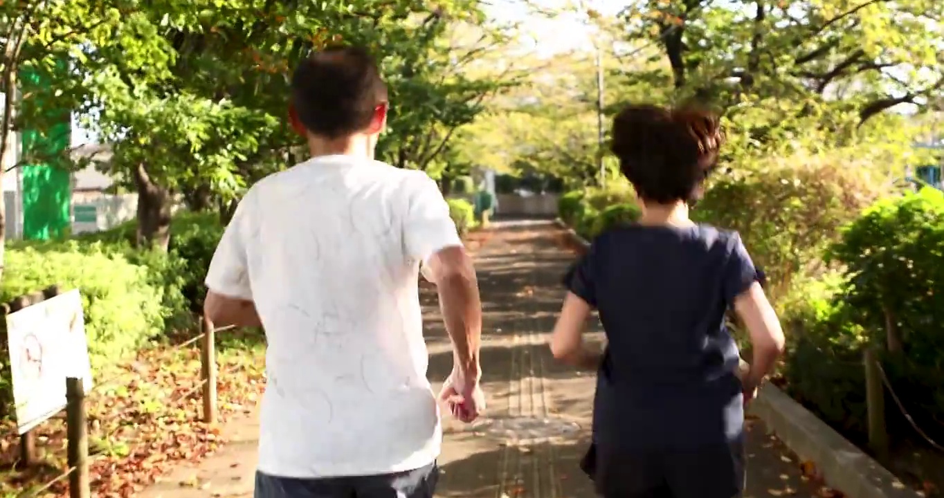 一对老夫妇互相鼓励对方开始在公园里跑步视频素材