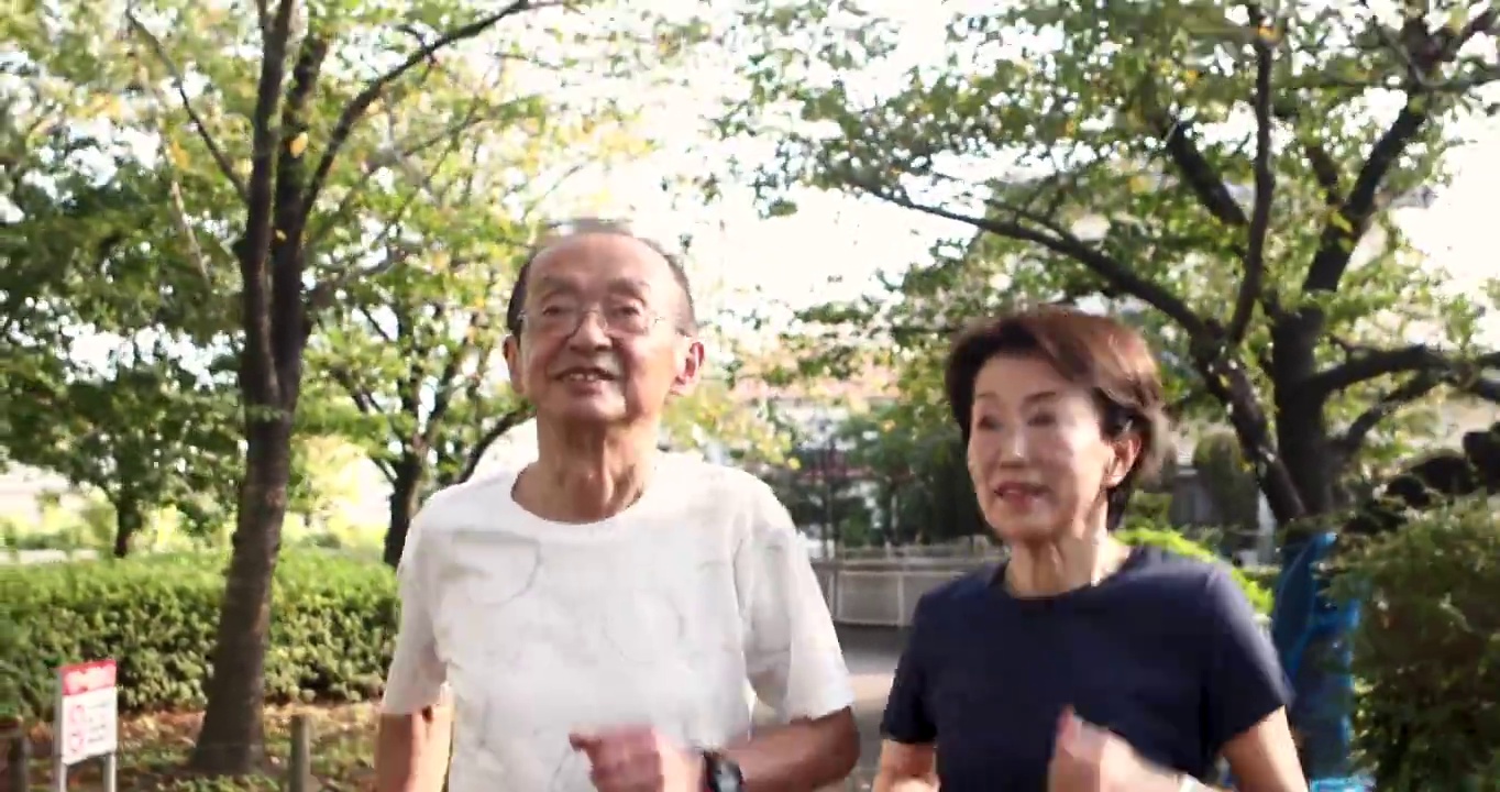 一对老夫妇互相鼓励对方开始在公园里跑步视频素材