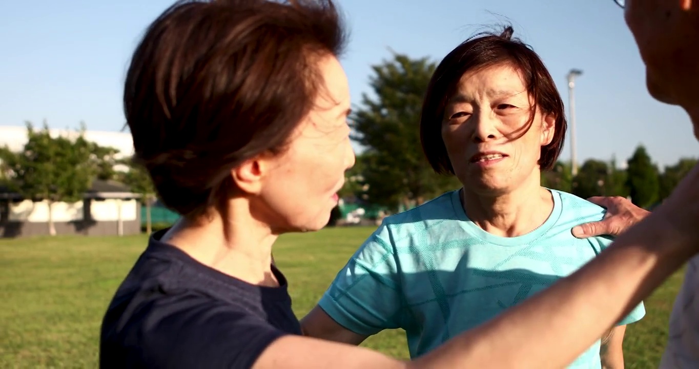 一位年长的女性在开始在公园慢跑之前会做一些预备运动视频下载