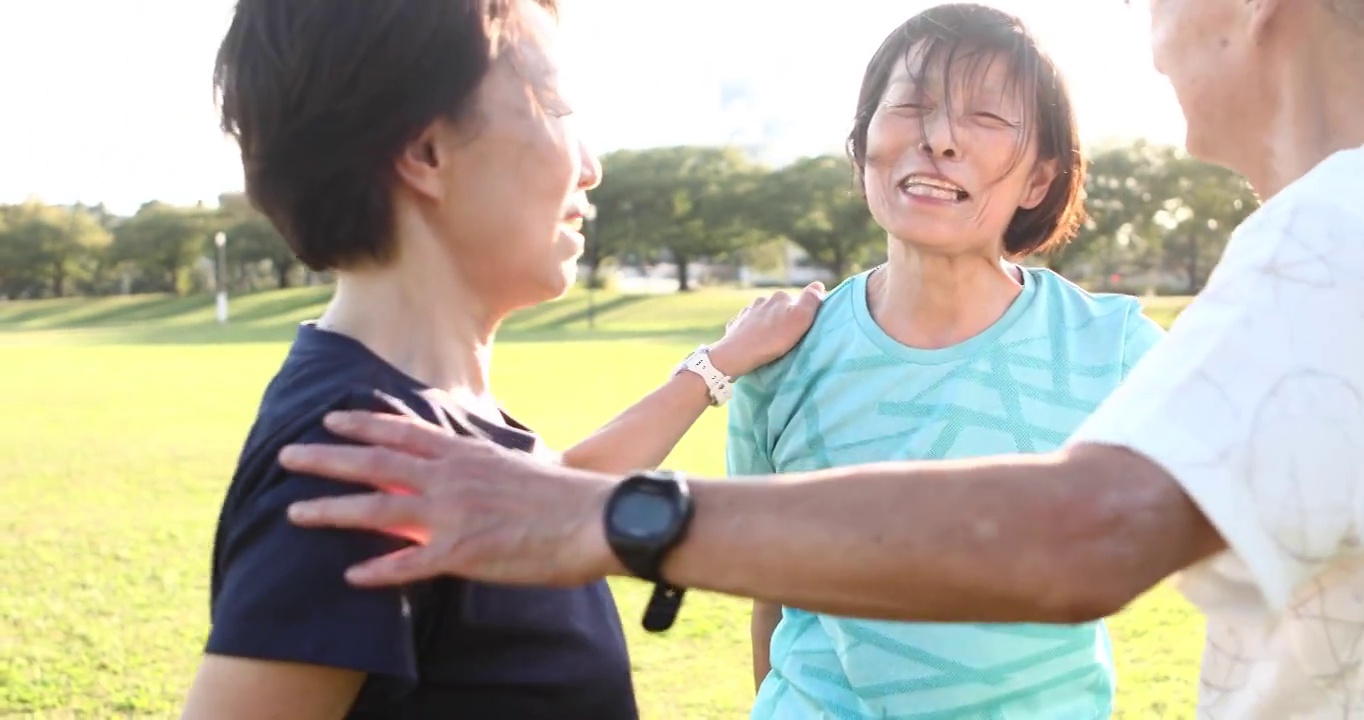 一名老年女性在公园慢跑前做准备运动时开始笑视频素材
