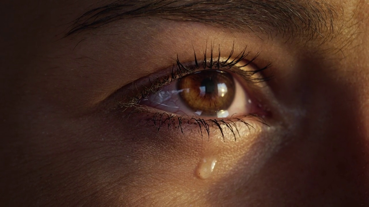 明亮的棕色眼睛的极端特写流眼泪。美丽的女性的脸视频素材
