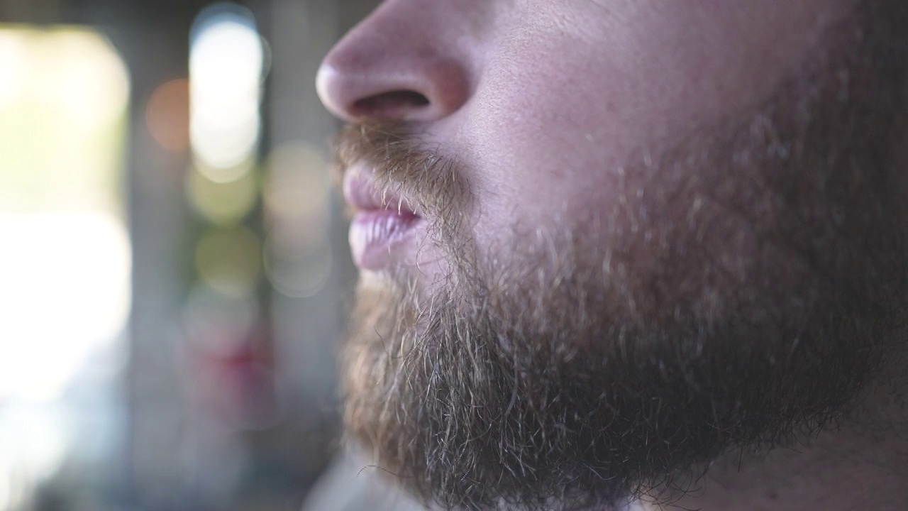 一名大胡子男子在餐馆里嚼吐司的慢动作视频视频素材