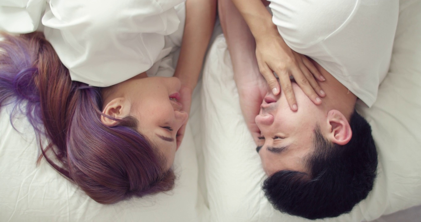 一对可爱的年轻亚洲夫妇在家里的床上度过了一个早上。视频下载