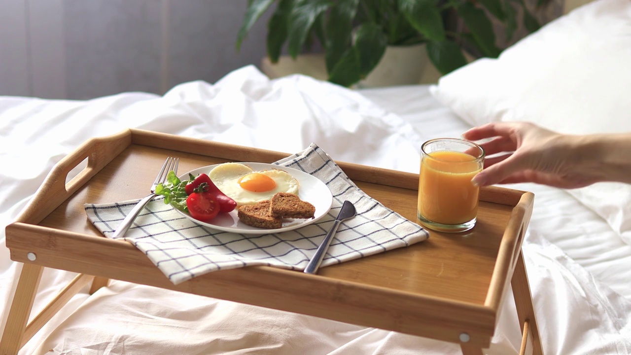 早餐放在床上的托盘上。早....心形煎蛋配蔬菜。视频下载