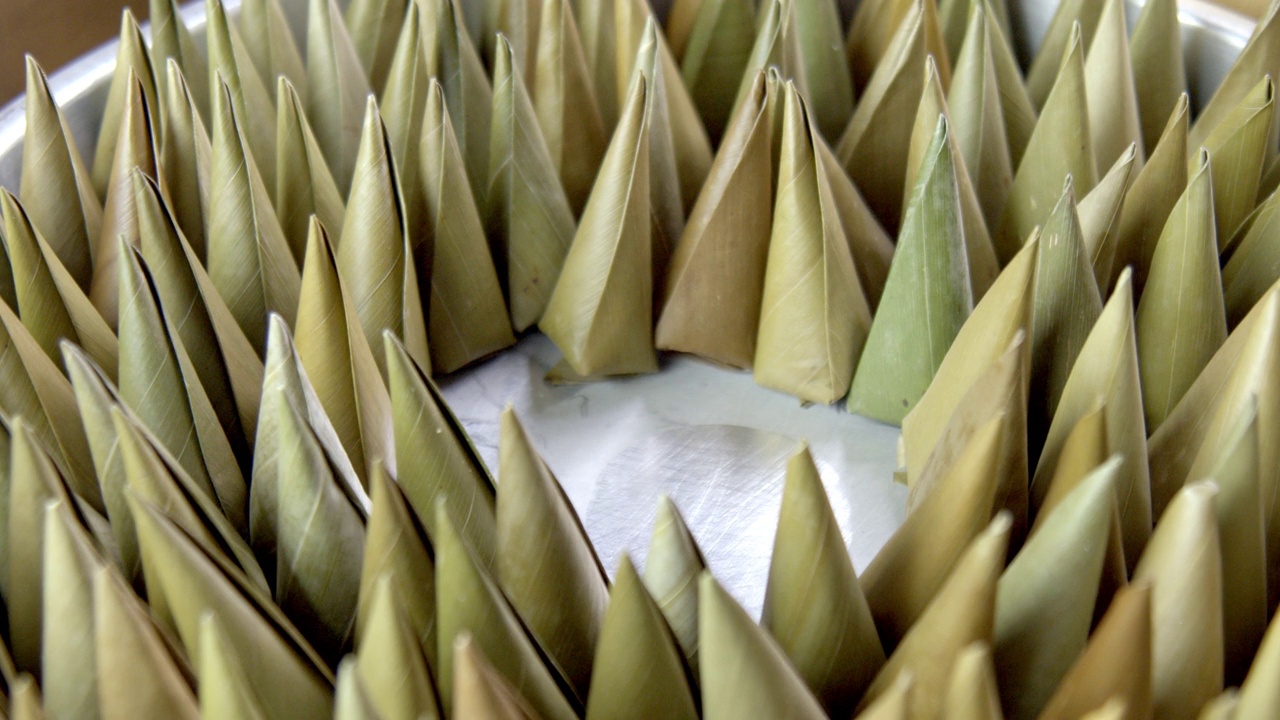 特写-手把金字塔或烛光形状的泰国甜点在香蕉叶，Khanom田，在中国新年的节日托盘。传统食品，糖果和糖果庆祝节日。视频下载