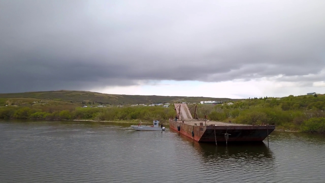 男工程师在废弃的驳船上工作的航拍照片，无人机在河上飞行-圣玛丽，阿拉斯加视频下载