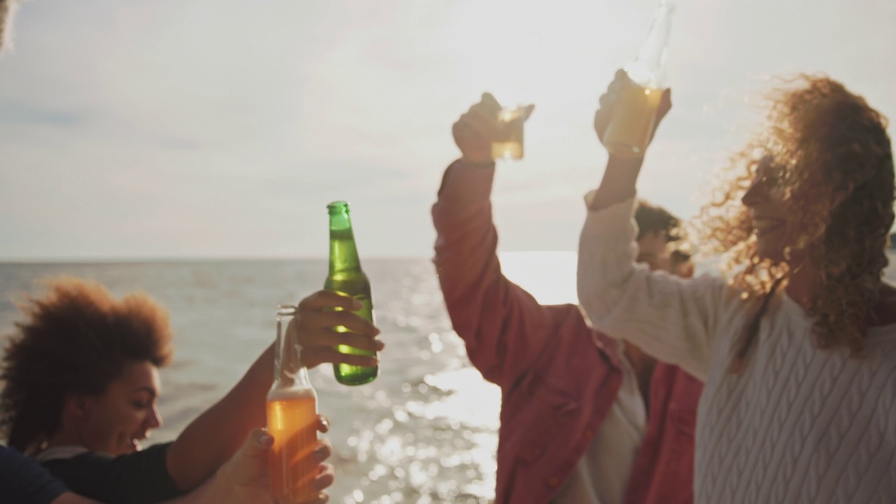 日落时分，一群朋友在船上开派对，喝着啤酒干杯视频下载