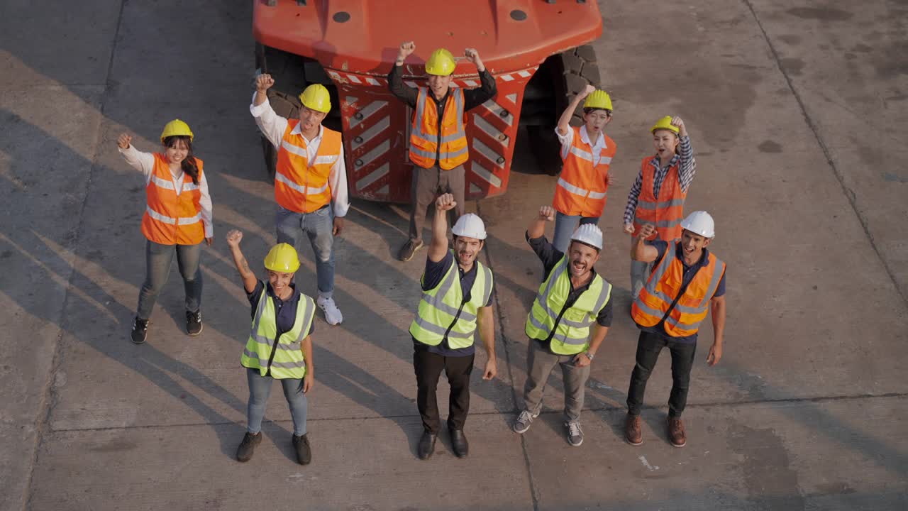 鸟的观点:一群在集装箱货仓工业工厂工作的年轻团队举起手来代表成功的工作视频下载