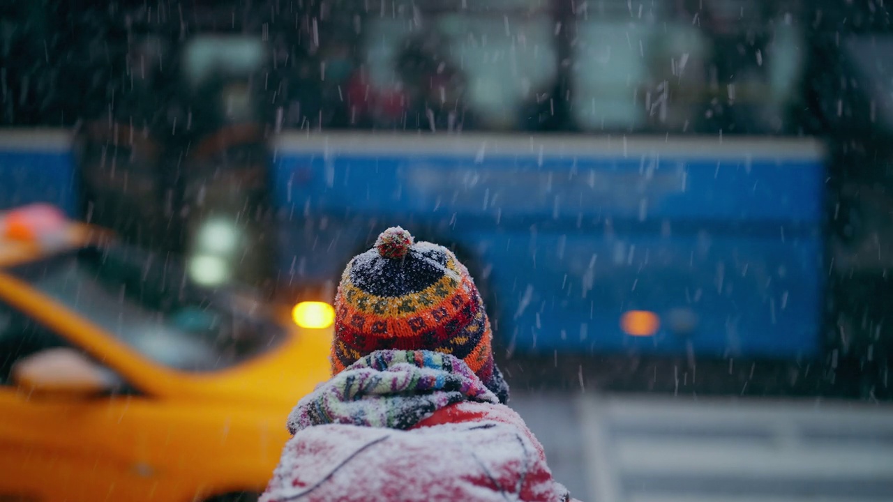 冬天，年轻的女游客在城市的红绿灯前等待视频下载
