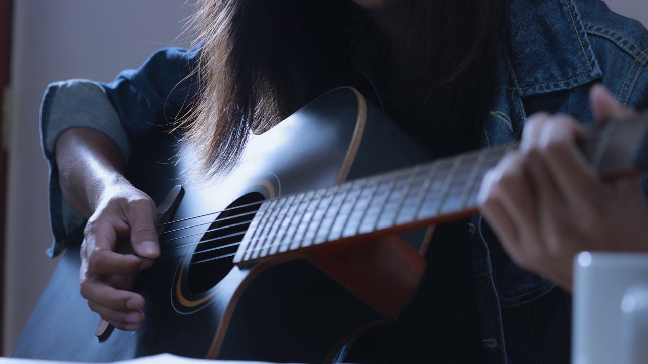 长头发的音乐家演奏原声吉他的特写视频素材