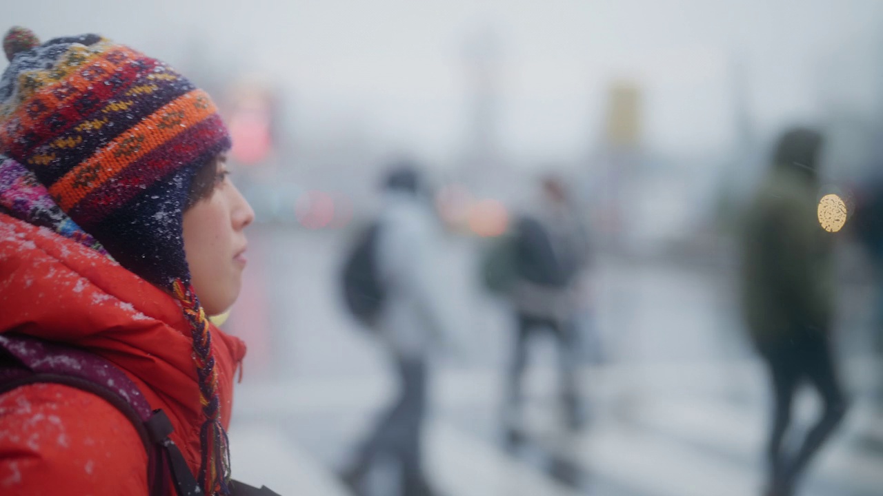 年轻的女游客在冬天的城市观光和过马路视频下载