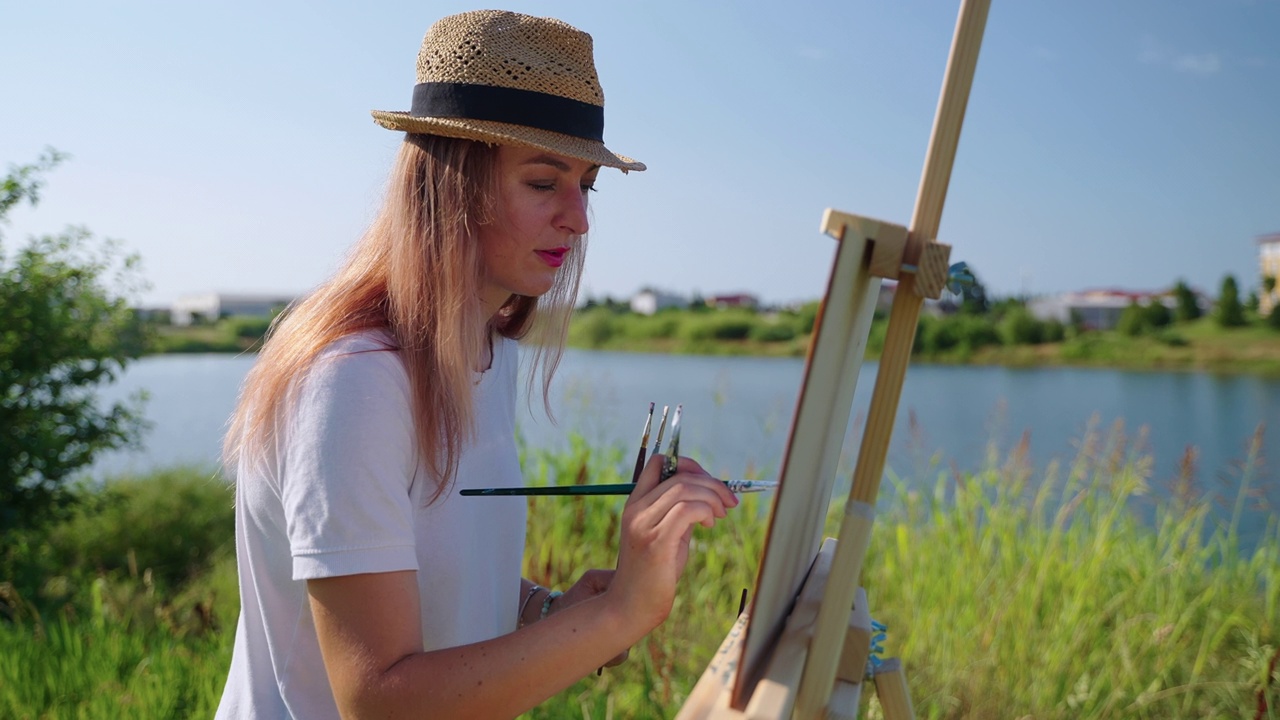 成年女性夏天周末的创作爱好，在公园里画画视频素材