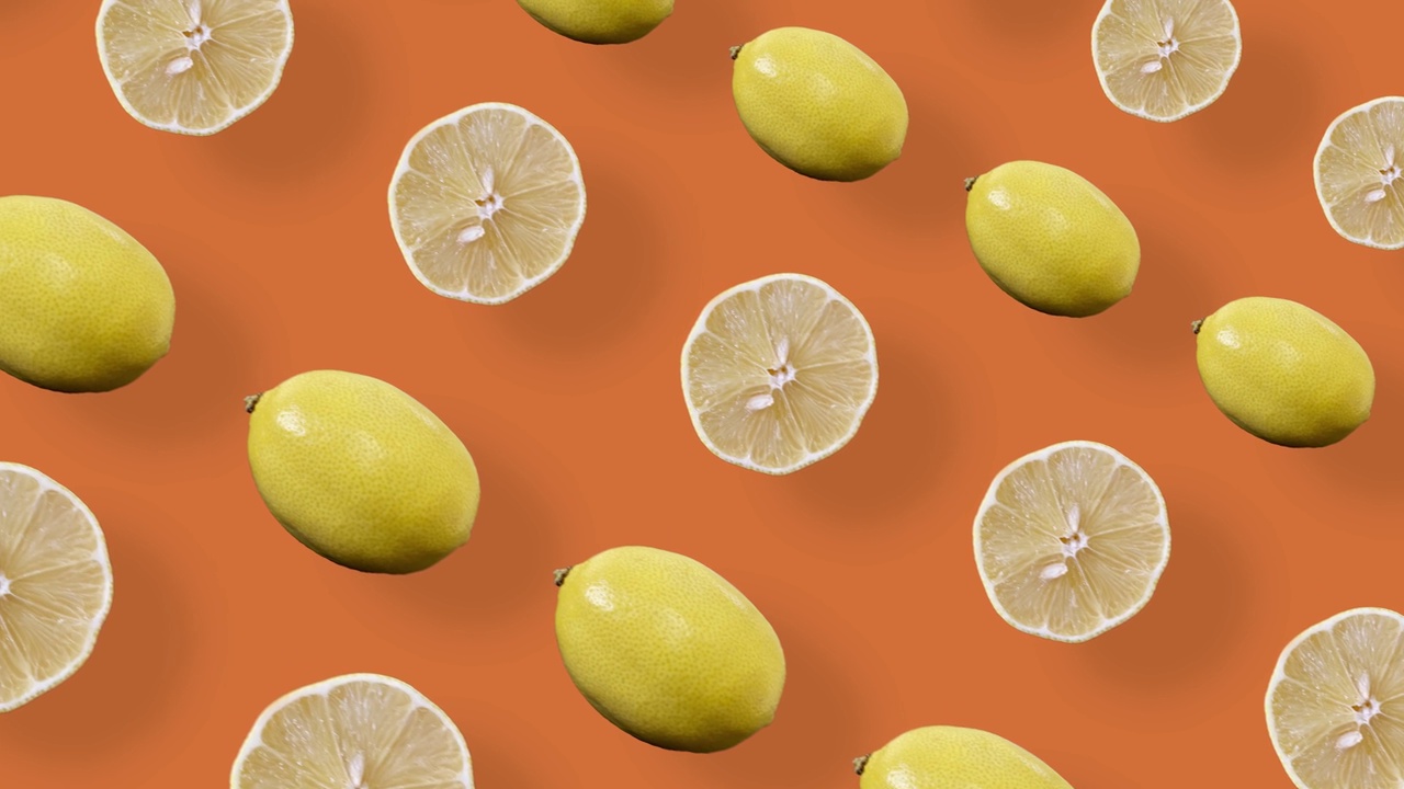 鲜艳的水果图案的新鲜柠檬在橙色的背景与阴影。无缝图案与柠檬片。现实的动画。4 k视频运动视频素材