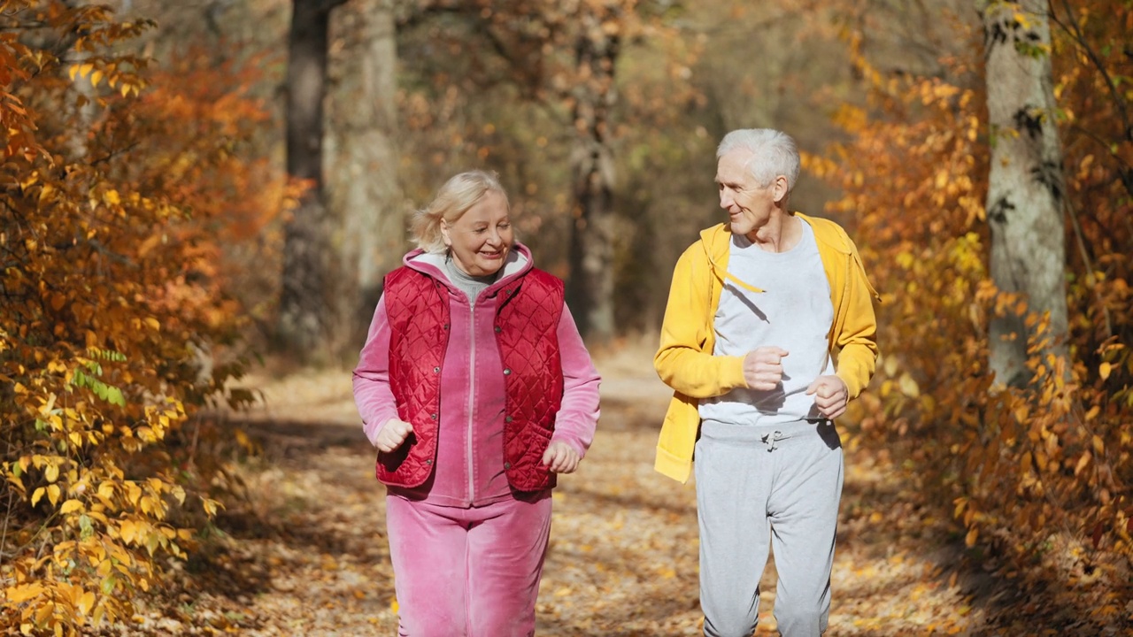 快乐的老年情侣在公园慢跑，健康积极的生活方式，慢动作视频下载