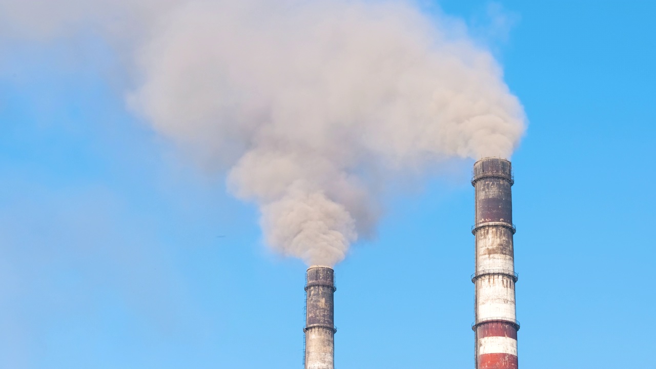 火力发电厂的高管与黑烟向上移动污染大气的特写。以化石燃料的概念生产电能视频下载