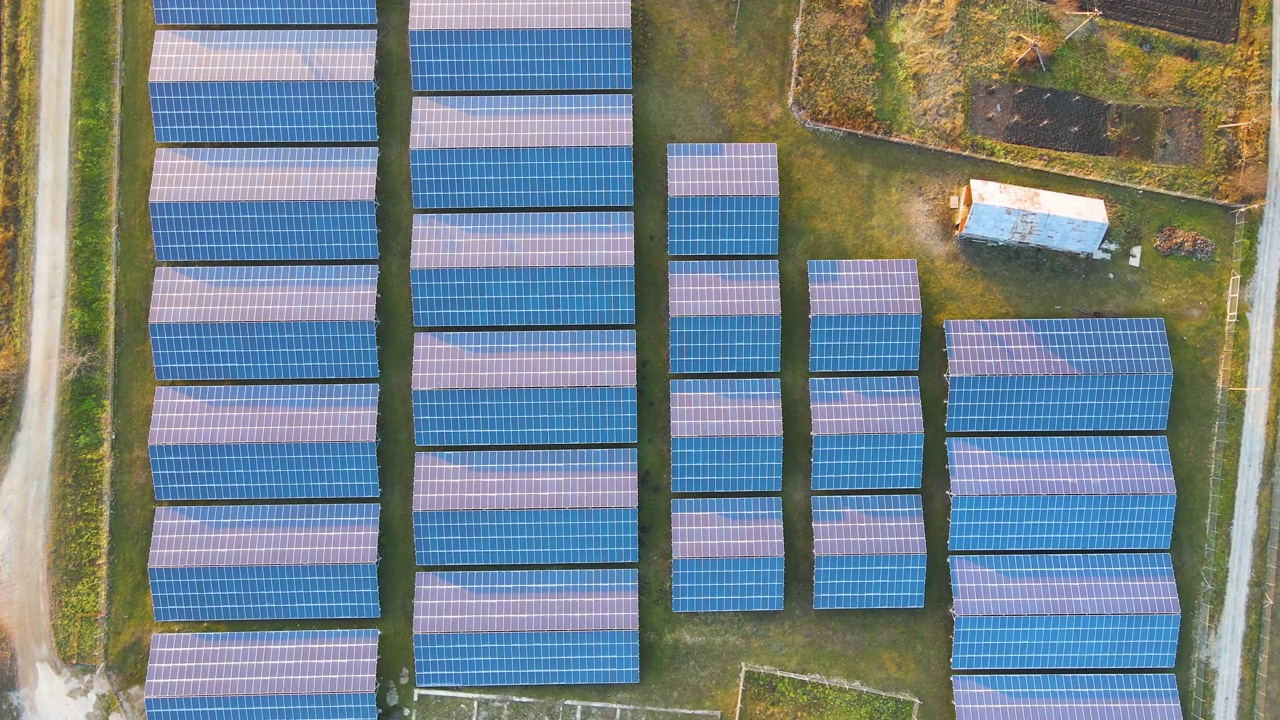 大型可持续发电厂鸟瞰图，一排排太阳能光伏电池板，用于生产清洁的生态电能。零排放的可再生电力。视频下载