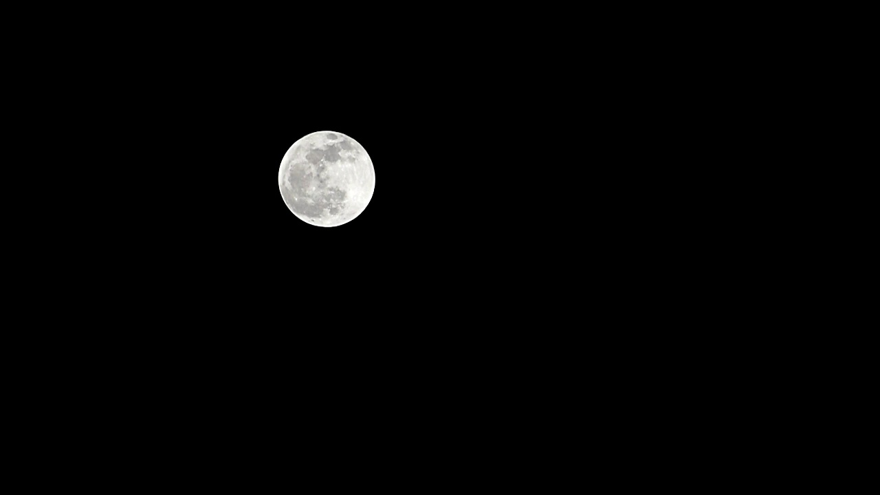 月亮时间推移，库存时间推移:满月上升在黑暗的自然天空，夜晚的时间。满月盘的时间随着月亮照亮了夜晚漆黑的天空。高质量的免费视频素材或时间间隔视频素材