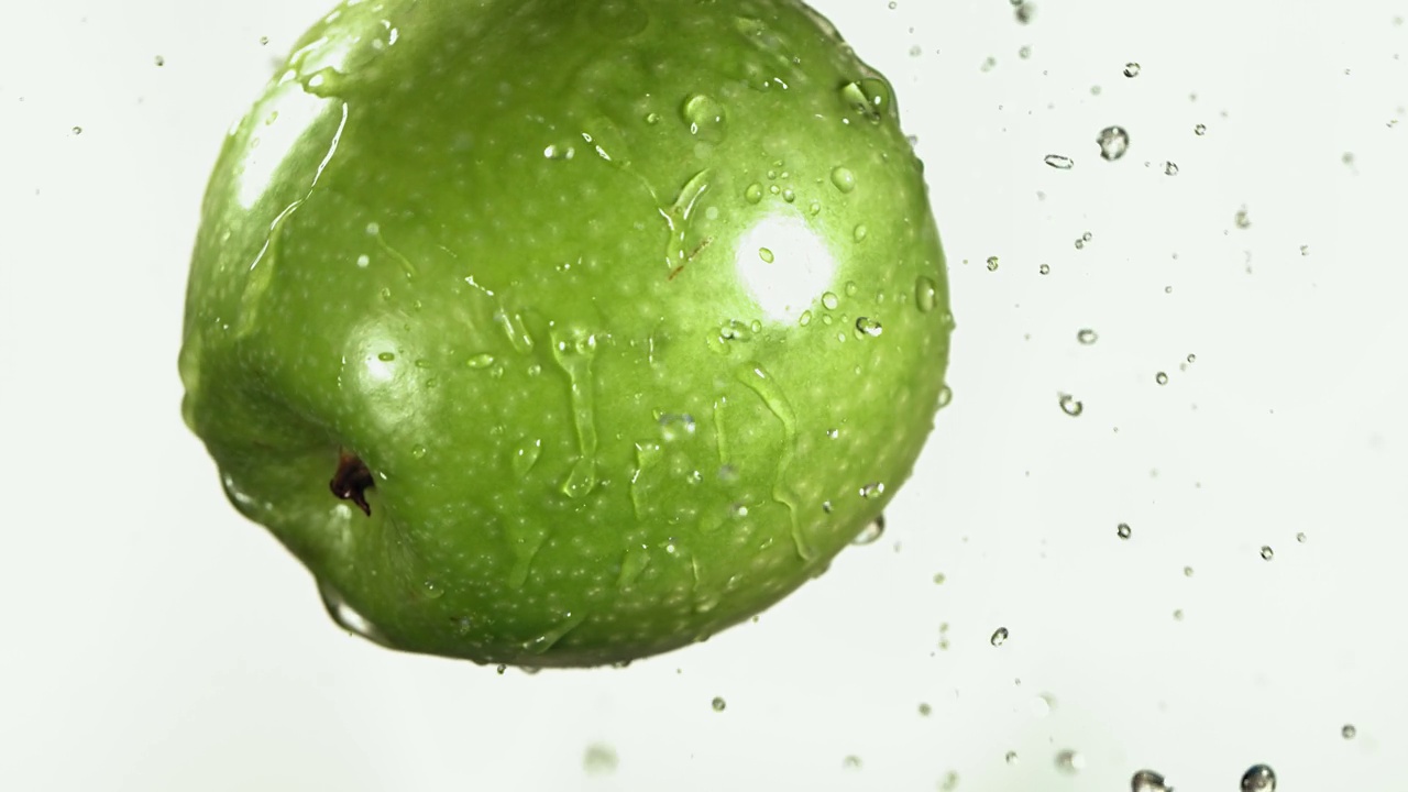 绿色苹果在白色厨房背景的飞行慢动作视频下载