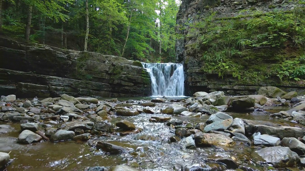 在夏季的森林里，山河上的瀑布，白色的泡沫水从岩石中落下视频下载