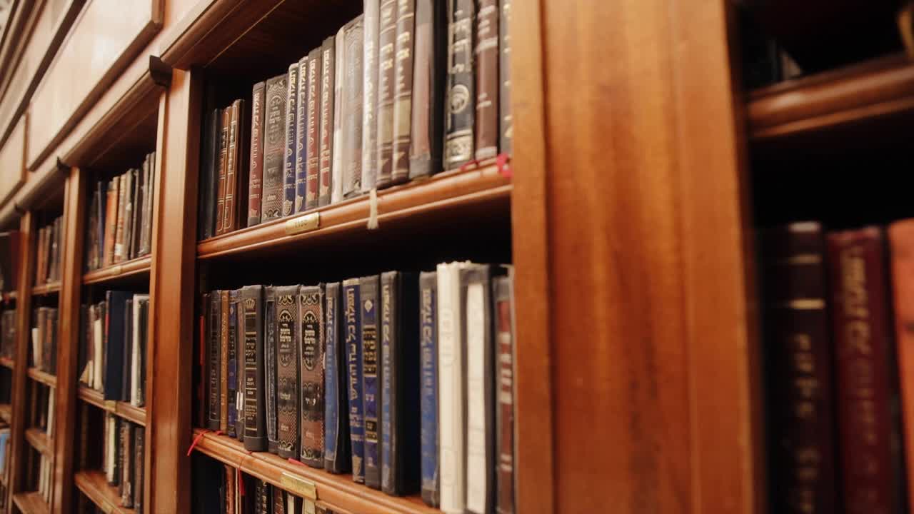 男人的手还在书架上的圣书。犹太图书馆的传统书籍:Torah, Talmud。犹太社区的历史建筑。耶路撒冷旧城视频素材