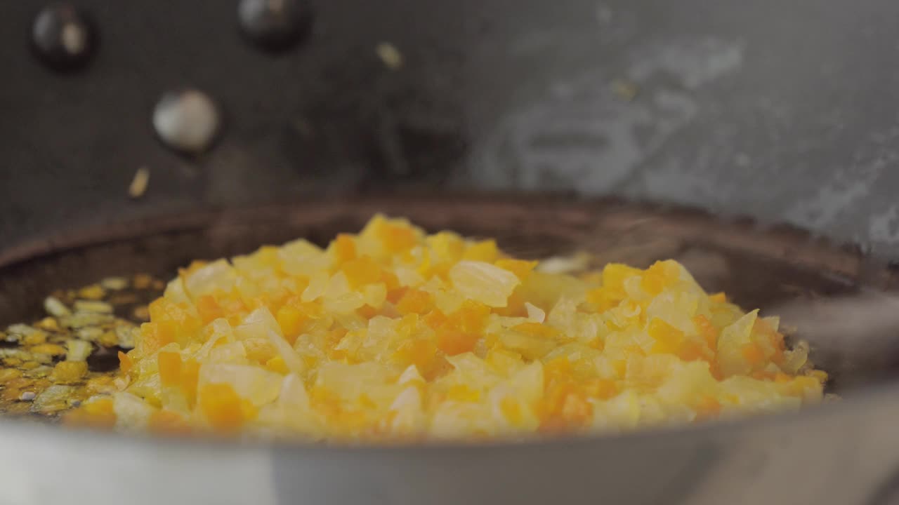烹饪蔬菜时，西葫芦片掉在锅里。食物镜头准备晚餐健康午餐用蔬菜坚果调味。视频素材