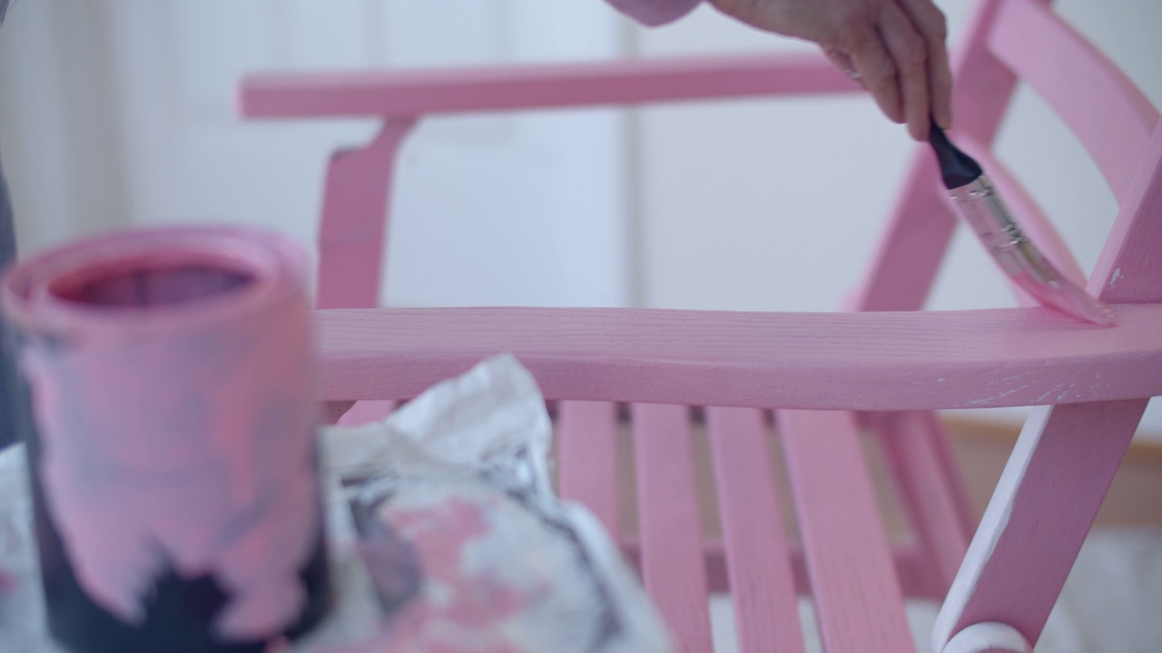 成熟女人的手把椅子漆成粉红色视频素材