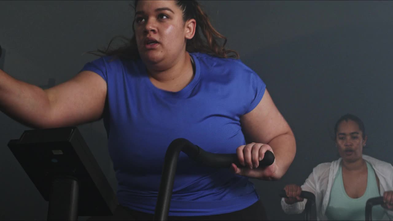 两个女人在健身房骑空中自行车锻炼的4k视频视频素材