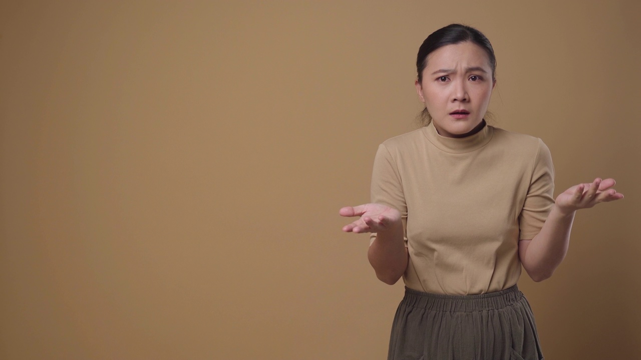 愤怒的亚洲妇女看着镜头孤立地站在背景上。4 k的视频视频下载