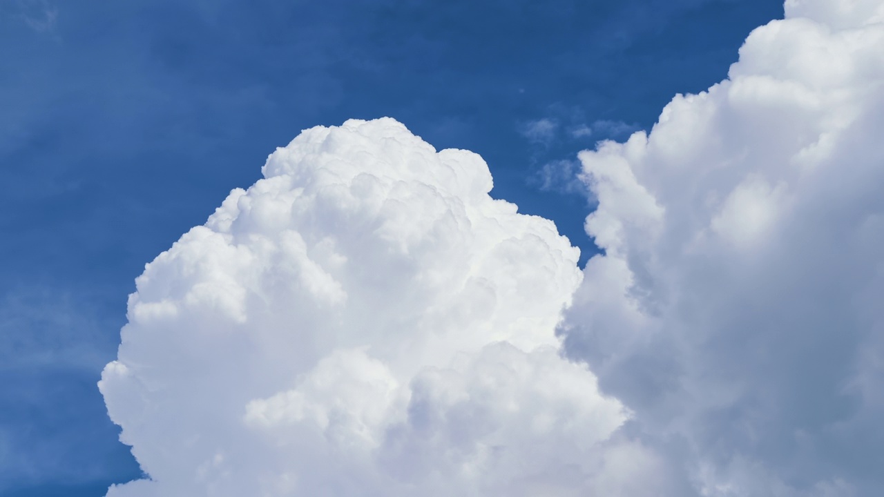 白色蓬松的积云在夏天的蓝天上逐渐形成。移动和变化的云景天气视频下载