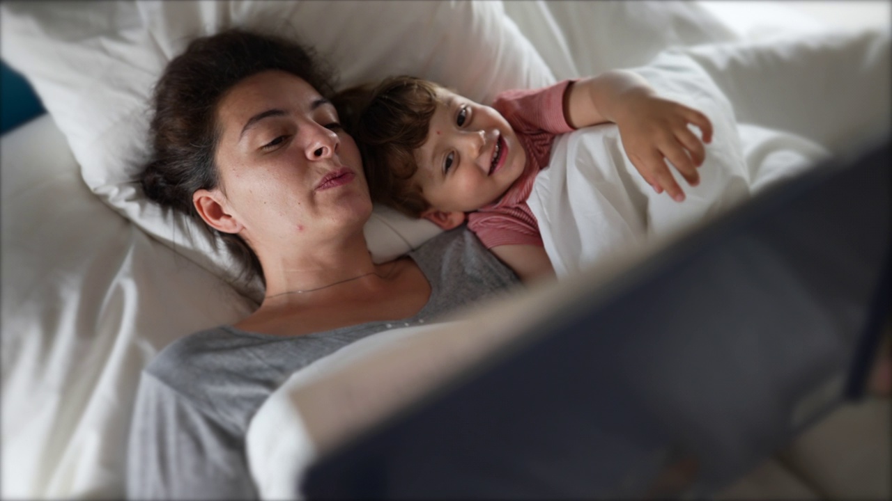 父母给躺在床上的孩子读睡前故事视频下载