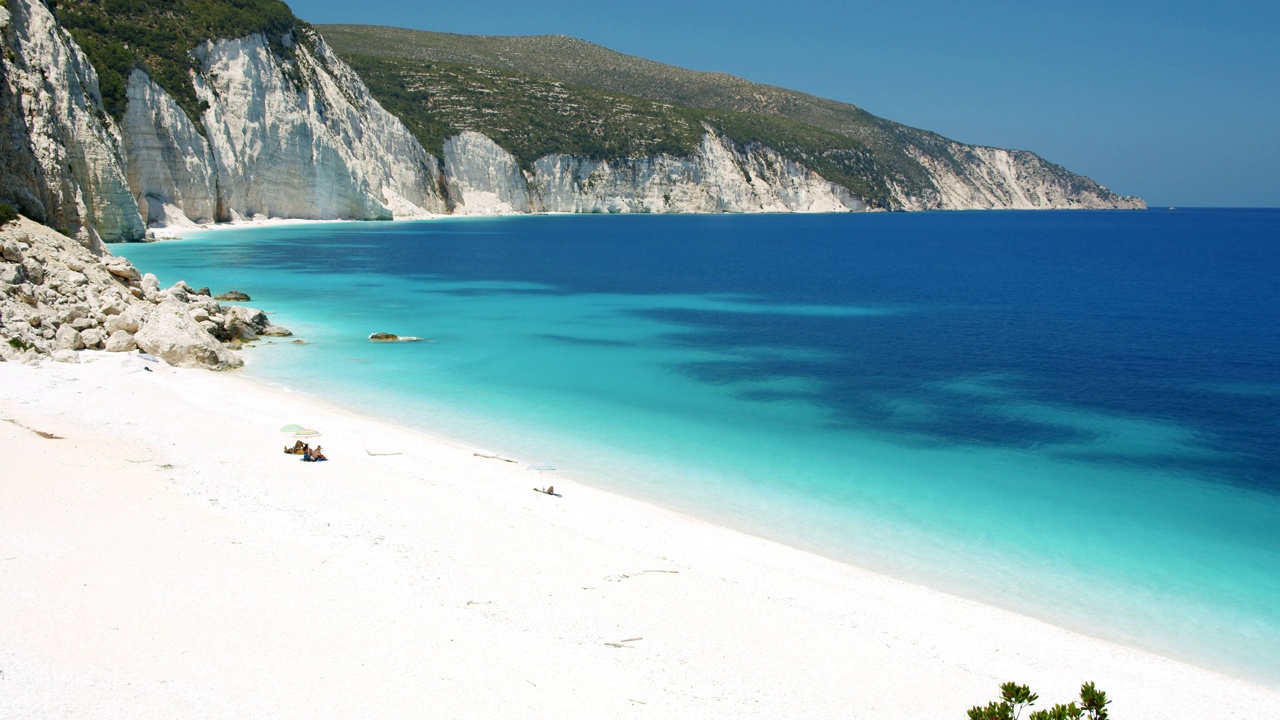 希腊凯弗拉尼亚岛僻静的弗特里海滩。白色的岩石和绿色树叶环绕的蓝色的泻湖视频下载