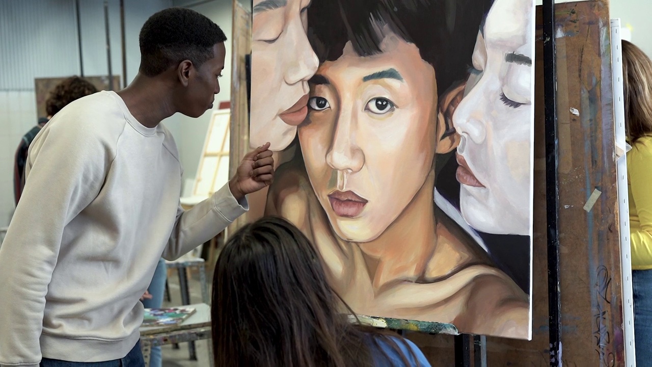 大学艺术教室里，多种族青年学生谈论油画视频下载