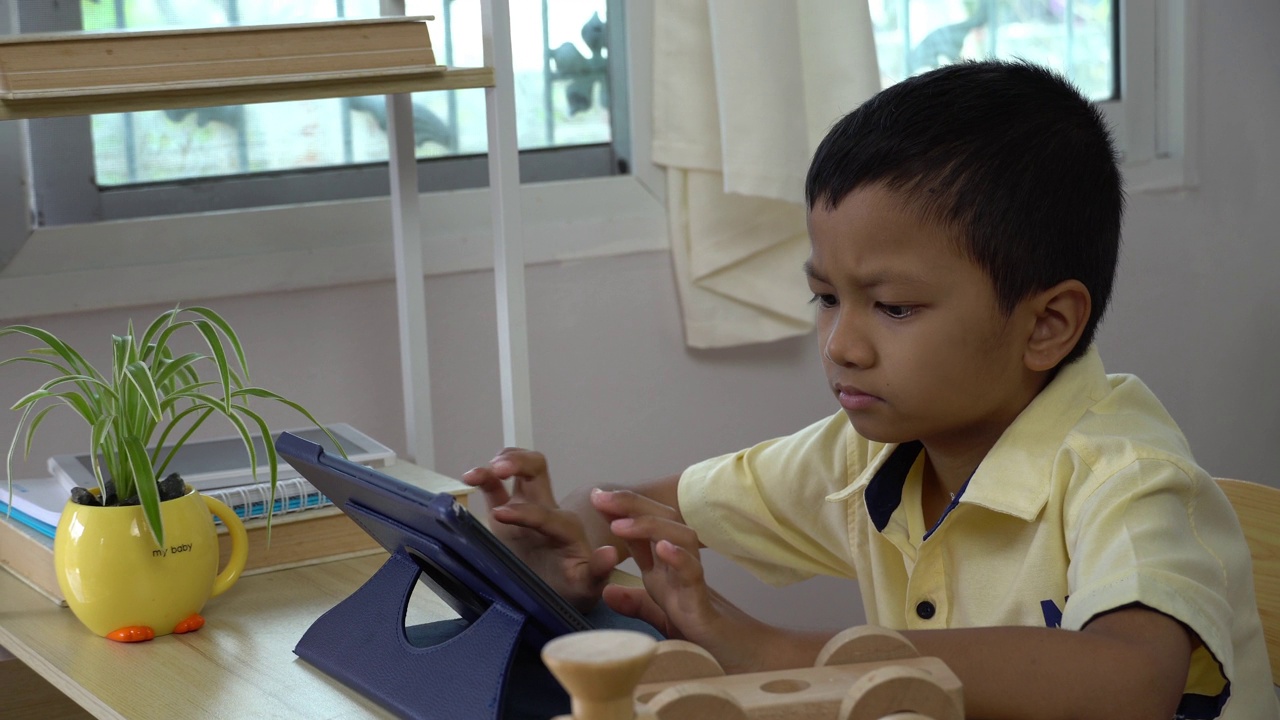 亚洲男孩在家用平板电脑学习。视频素材