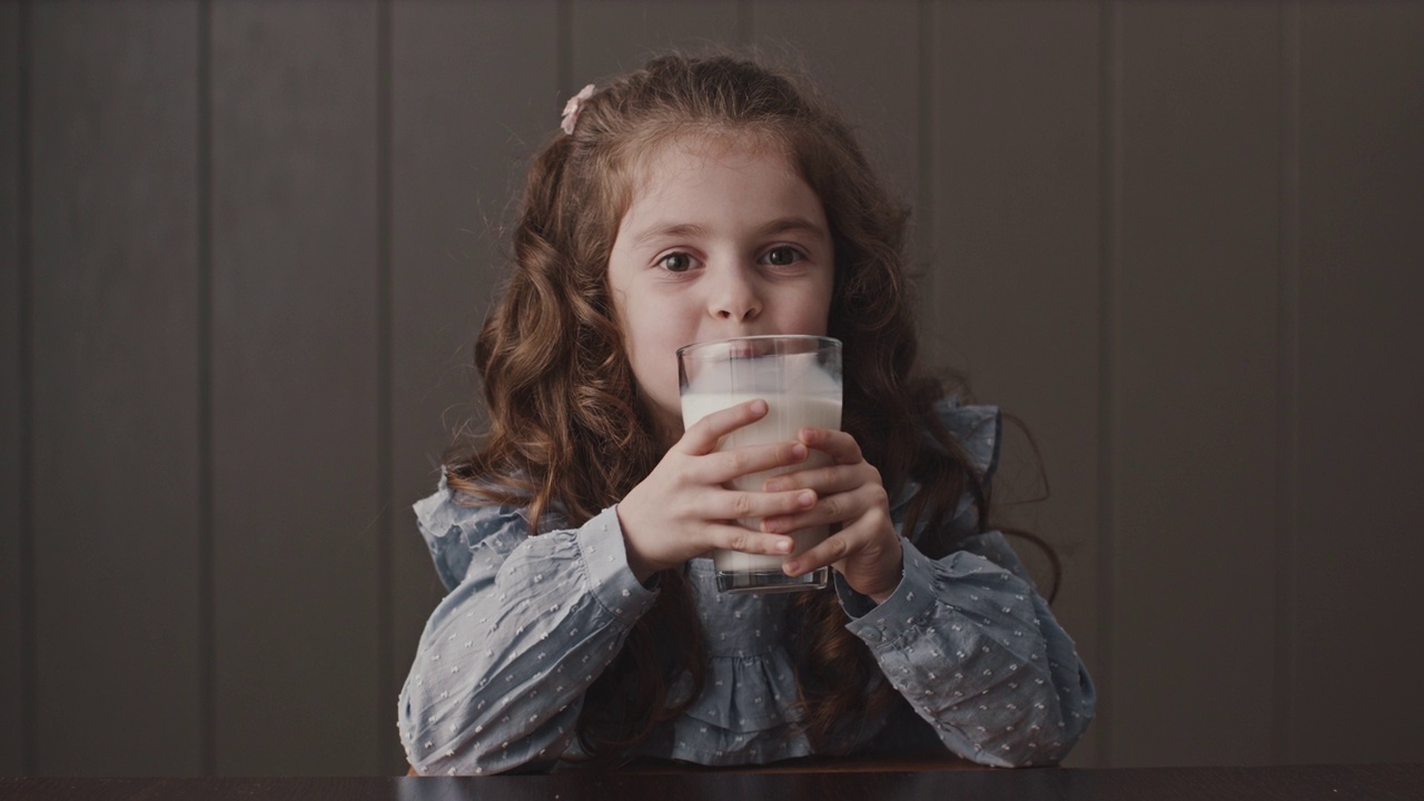 大头照，欢快的小女孩拿着杯子喝着牛奶视频下载