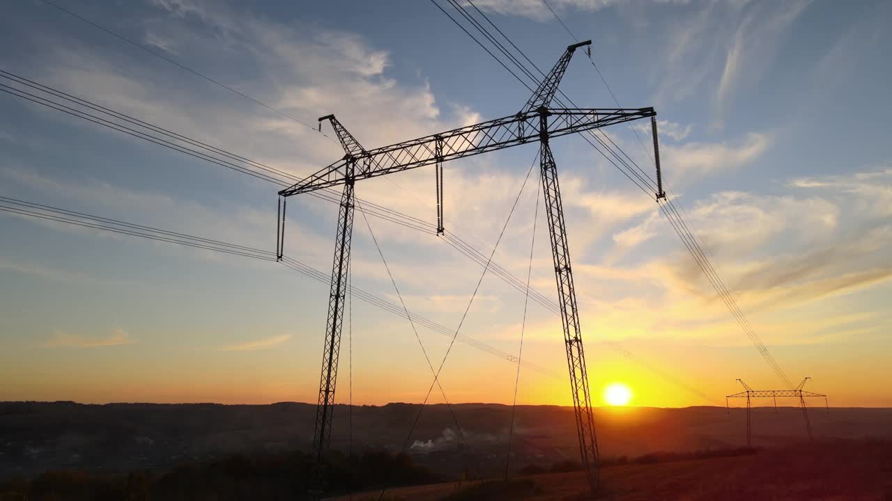 日落时分带电线的高压塔。传输的电力视频下载