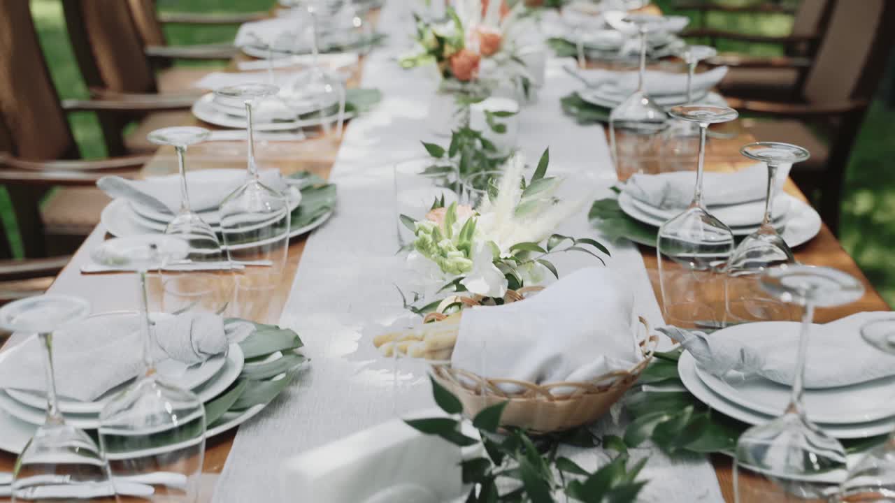 装饰周年纪念餐桌。婚礼餐桌装饰与自然鲜花的花束与家人的晚上视频下载