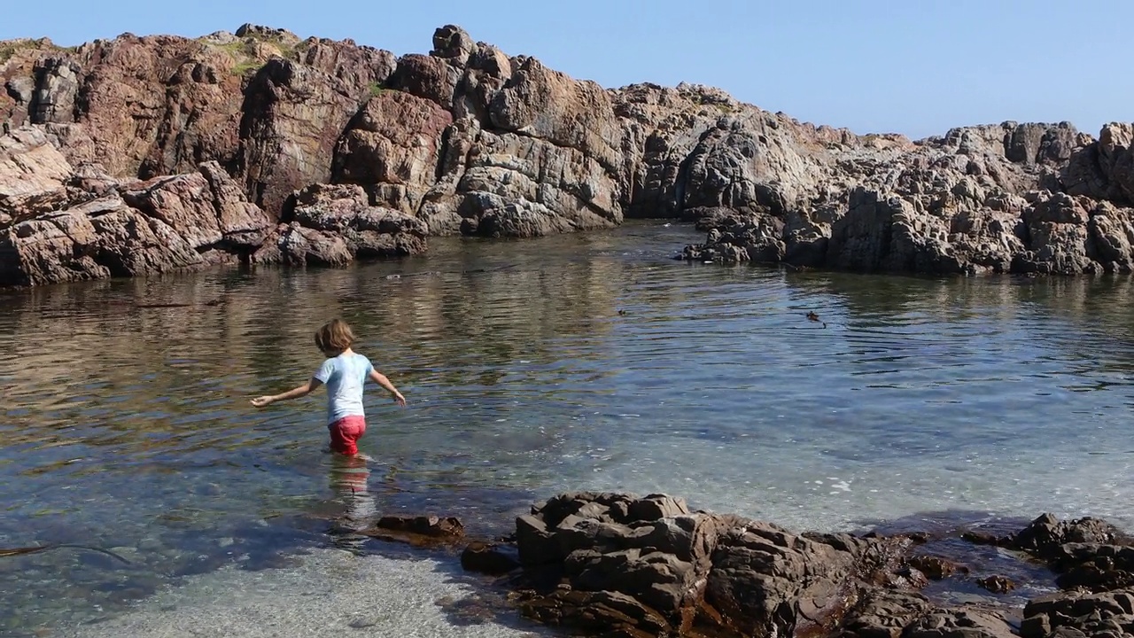 十几岁的女孩和弟弟探索岩石海岸线视频素材