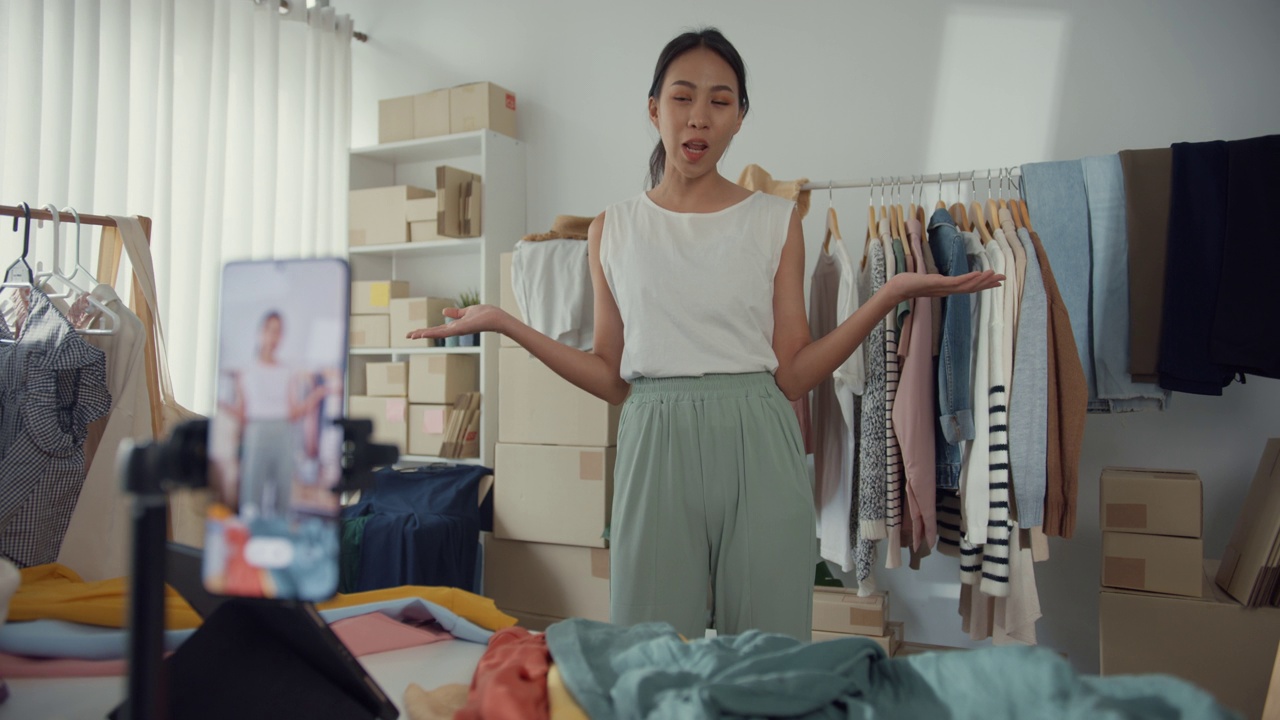 亚洲女商人在线直播电子商务在家里卖衣服。视频素材