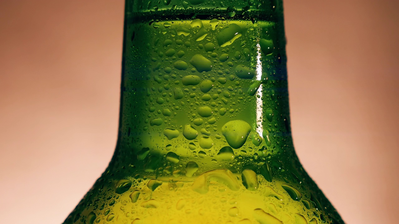 冷凝水滴在绿色啤酒瓶上视频下载