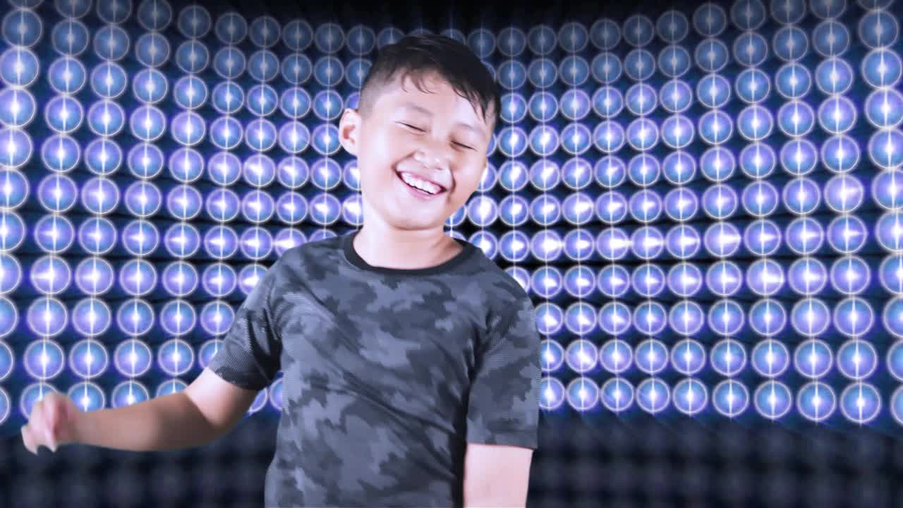 快乐的小男孩享受音乐，同时跳舞与图形均衡器的背景视频下载