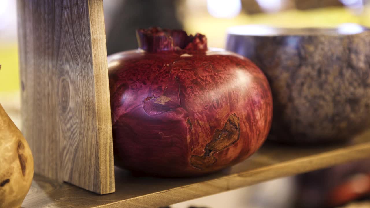 近距离观察一个手工制作的石榴形状的木制花瓶在车间里。艺术。架子上漂亮的手工木制花瓶视频下载