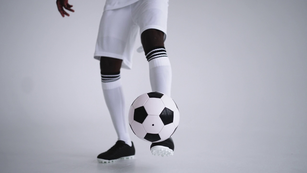 通过足球保持向上，特写球员的脚踢和握球，技术技能视频素材