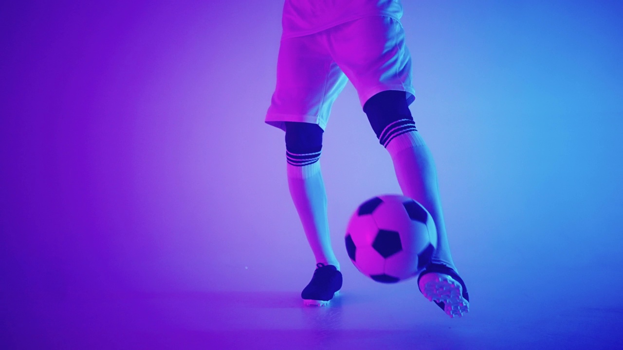 保持有才华的足球运动员的技能，特写脚在足球靴和球在工作室视频素材