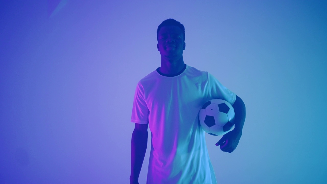 年轻的非洲足球运动员的肖像在工作室，少年非洲裔美国运动员与足球视频素材