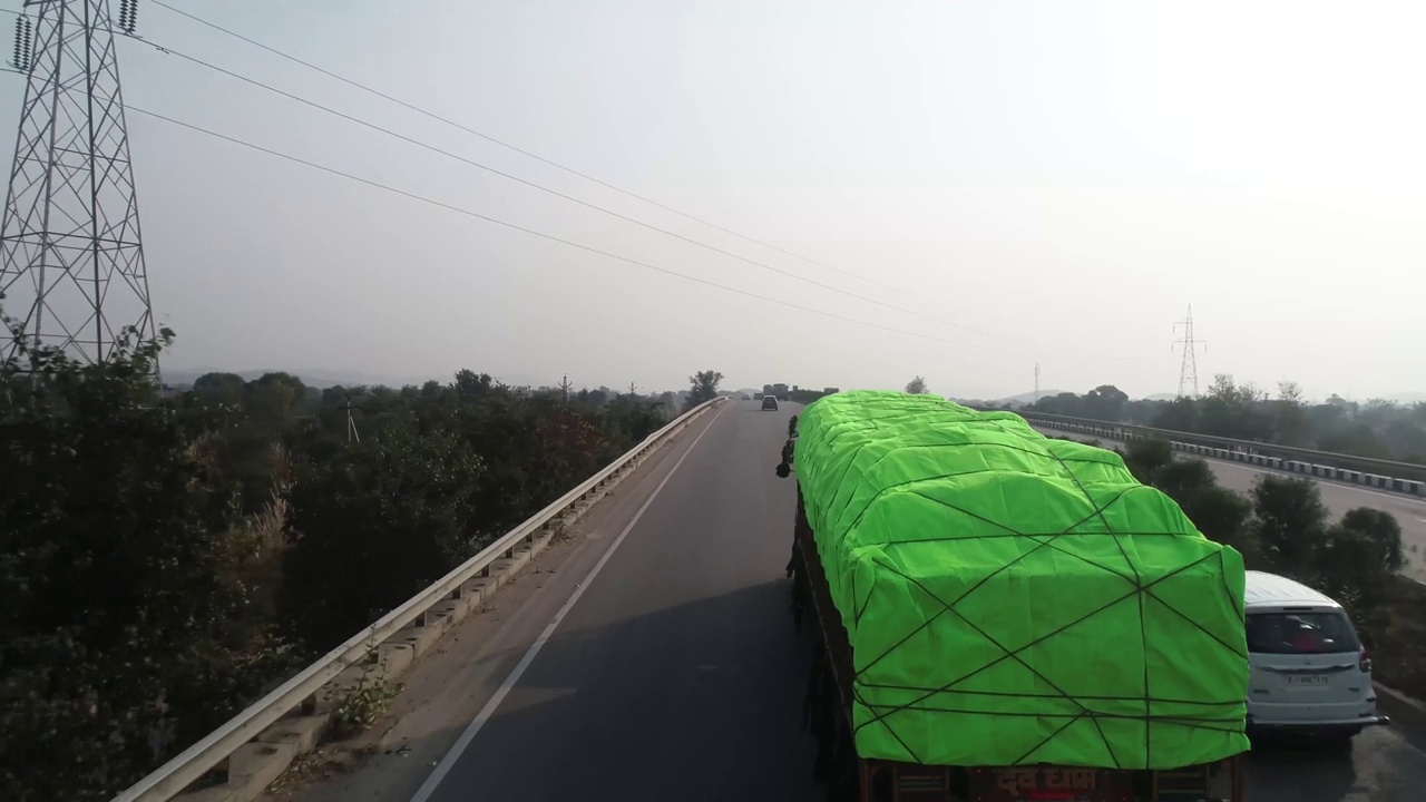无人机拍摄的超载卡车在德里斋浦尔高速公路上行驶视频下载