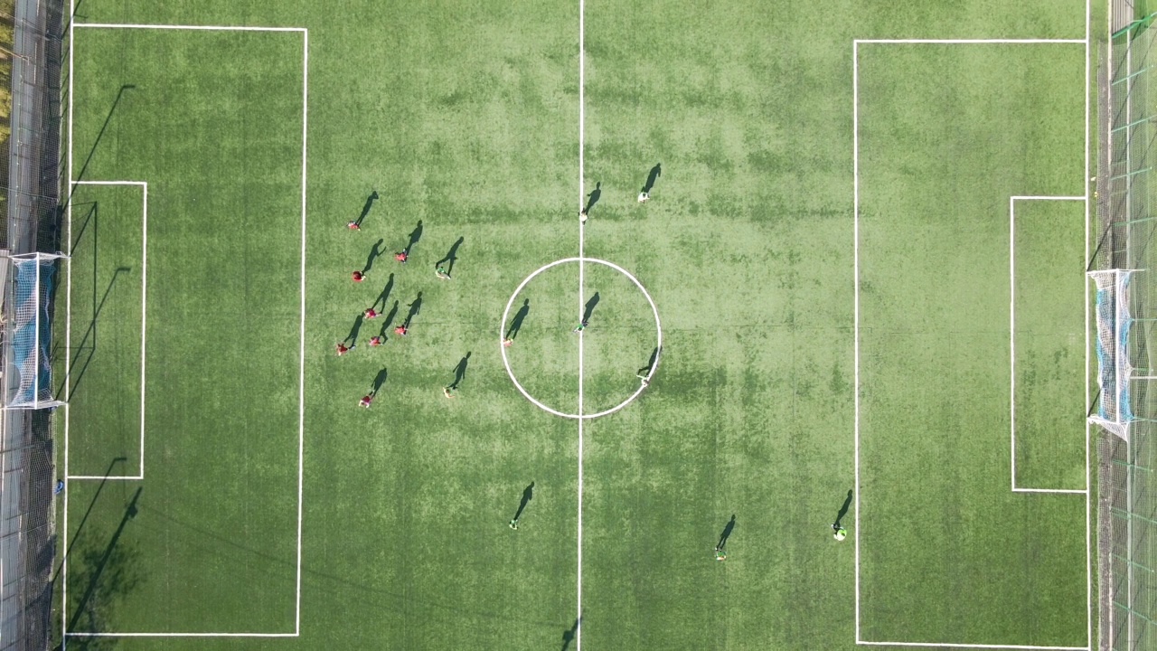 足球运动员在绿色的体育场踢足球的鸟瞰图视频素材