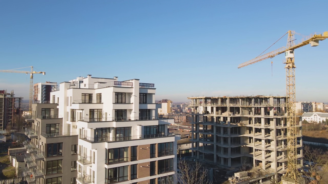高塔起重机和正在建设中的住宅公寓的鸟瞰图。房地产开发视频素材