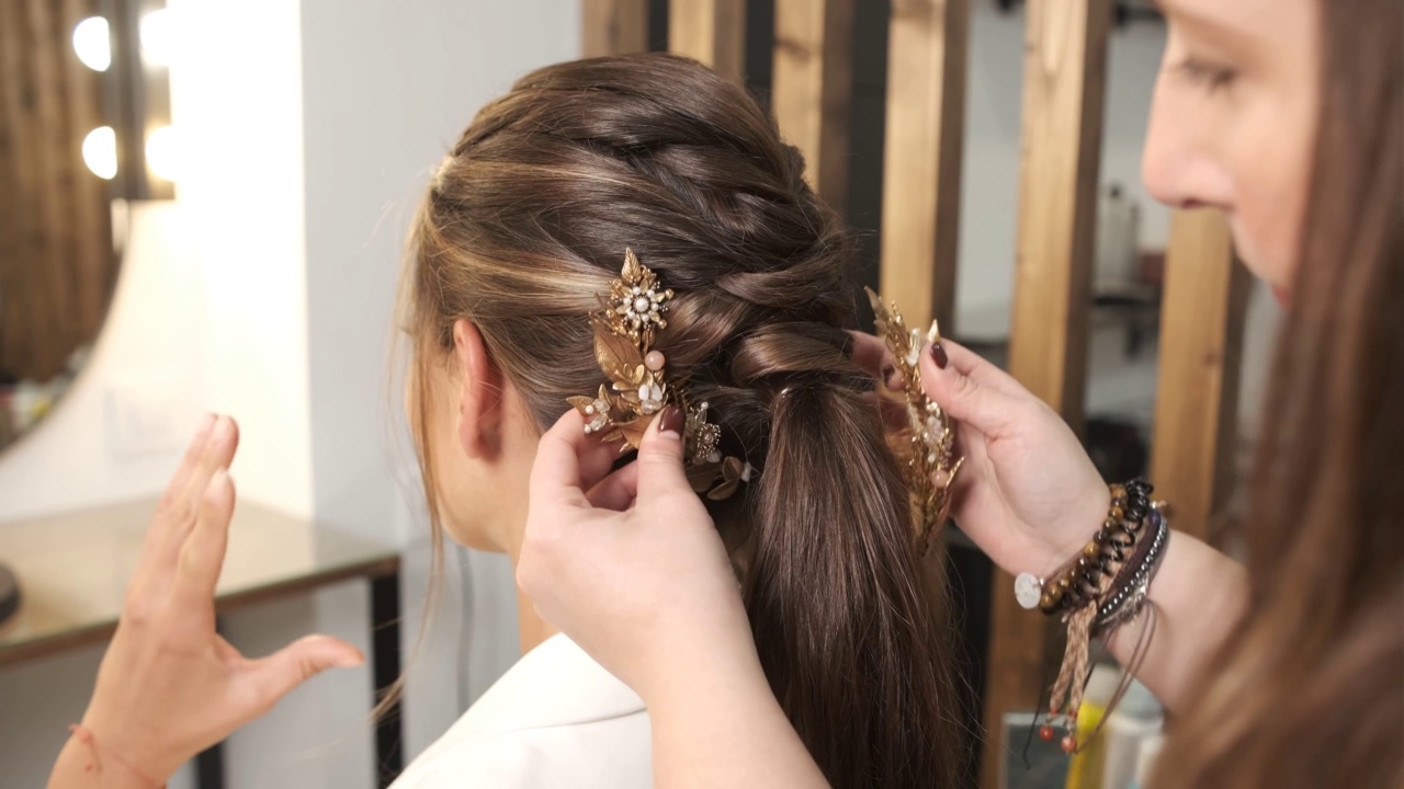 美发师在给客户做婚礼发型时给她戴上时尚的发饰。视频素材