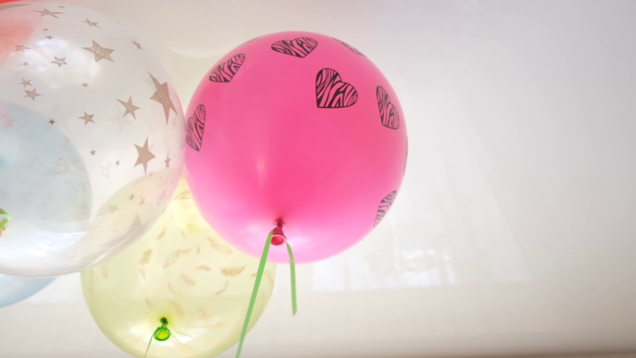 五颜六色的氦气球上升，漂浮在天花板下的空气中。C视频下载