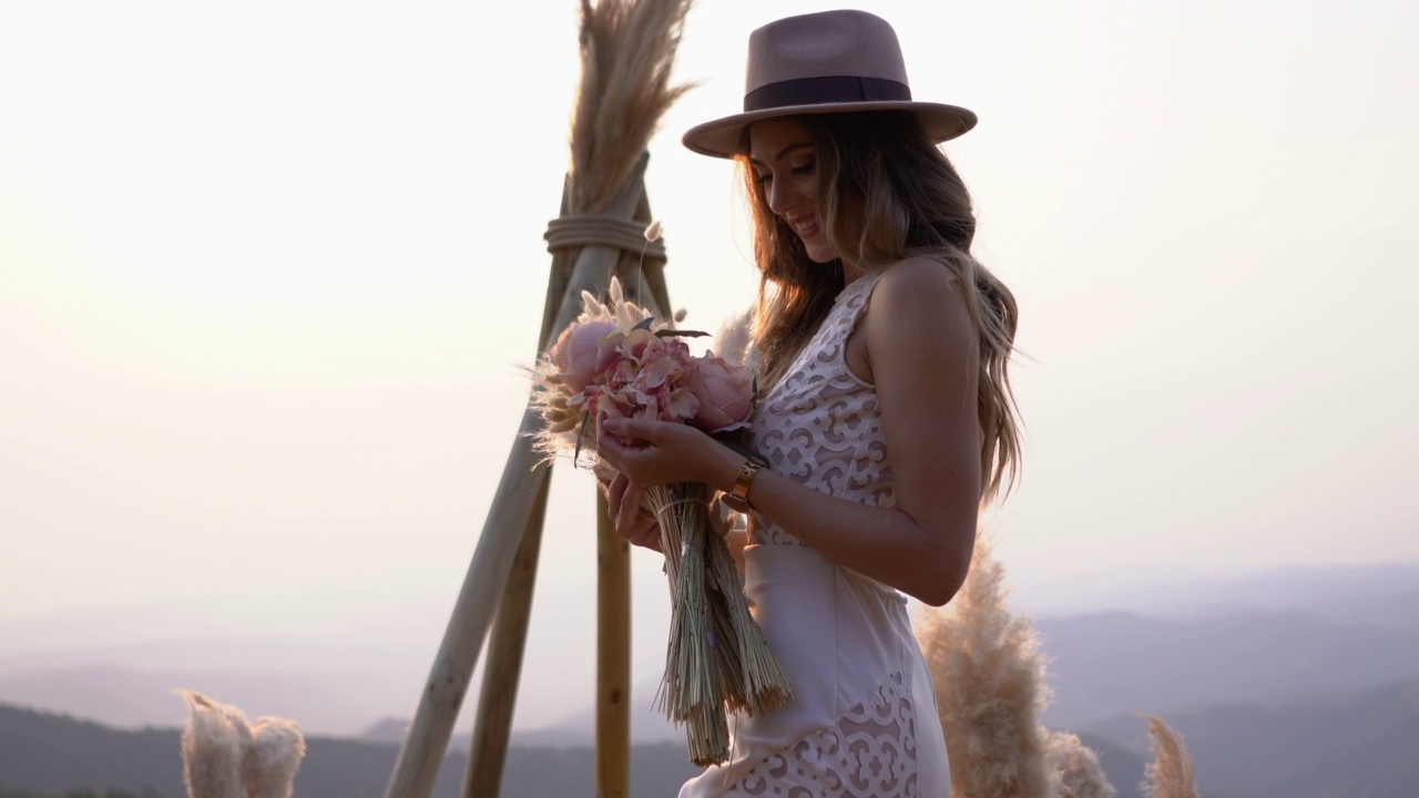 美丽的年轻新娘与花束摆姿势在大自然视频素材